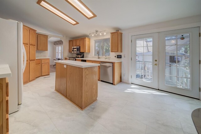 kitchen with lofted ceiling, sink, a center island, stainless steel appliances, and french doors