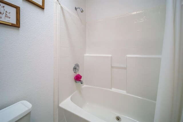 bathroom featuring toilet and shower / bath combination