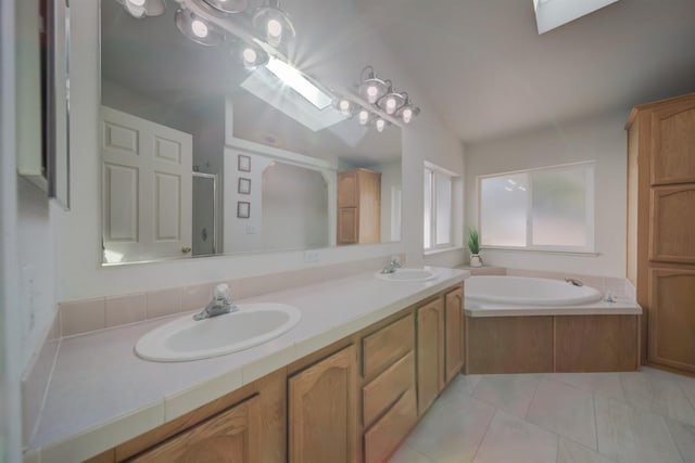 bathroom featuring vanity, vaulted ceiling with skylight, separate shower and tub, and tile patterned flooring