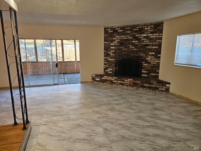 unfurnished living room with baseboards, a healthy amount of sunlight, and a fireplace