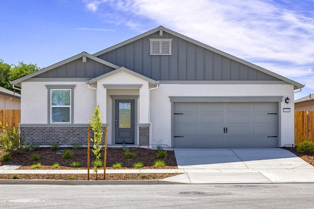 view of front of home featuring concrete driveway, stucco siding, fence, board and batten siding, and a garage