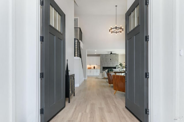 hall with light hardwood / wood-style floors and an inviting chandelier