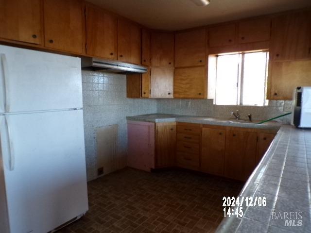 kitchen featuring white appliances, tasteful backsplash, and sink