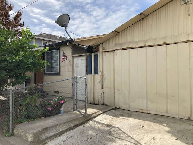 view of property exterior with crawl space, fence, and a gate