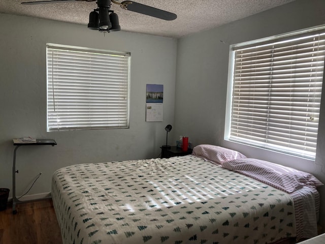 bedroom featuring a textured ceiling, a ceiling fan, and wood finished floors