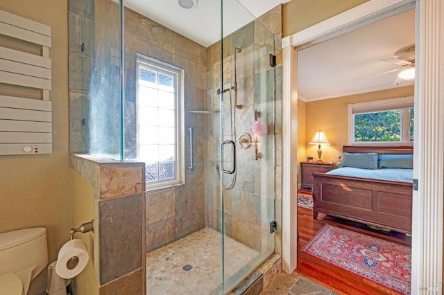 bathroom with toilet, ceiling fan, walk in shower, crown molding, and hardwood / wood-style flooring