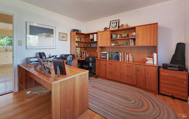 office space with ornamental molding, sink, and light wood-type flooring