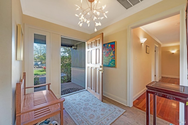 foyer entrance featuring ornamental molding, a chandelier, and light wood-type flooring