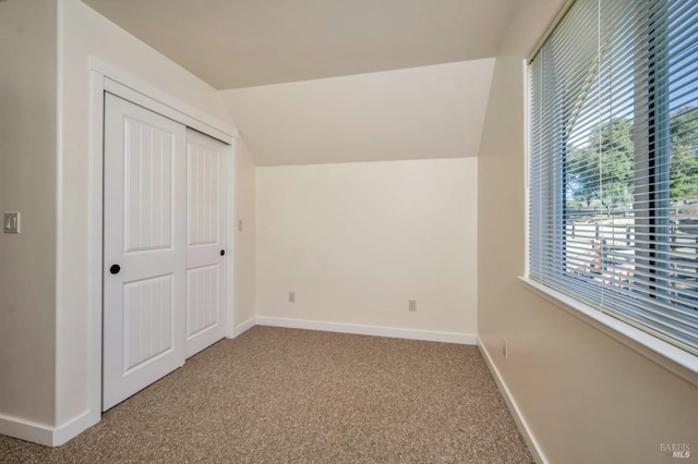 unfurnished bedroom with a closet, carpet flooring, and vaulted ceiling