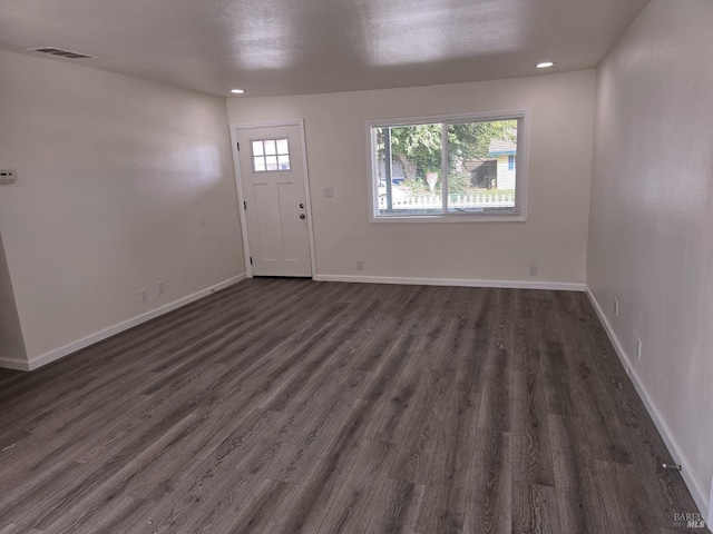 foyer entrance with a healthy amount of sunlight and dark hardwood / wood-style flooring