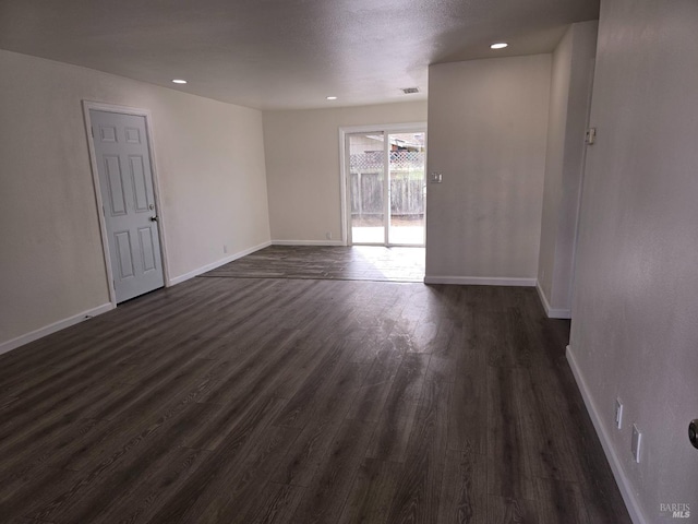 spare room with dark hardwood / wood-style flooring and a textured ceiling