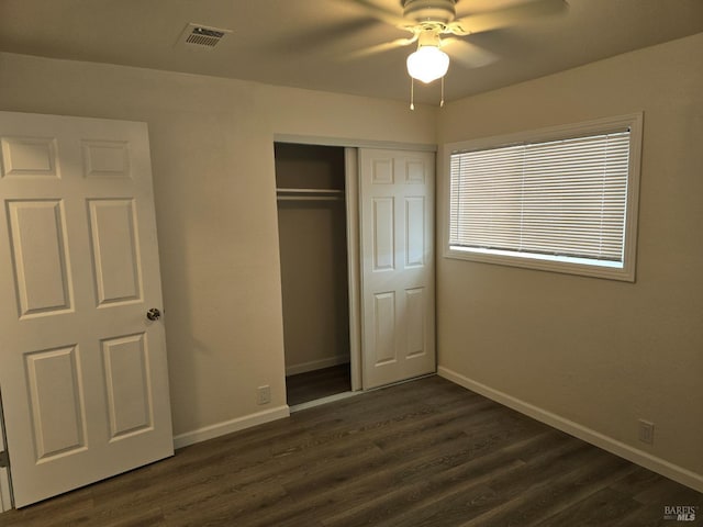 unfurnished bedroom with ceiling fan, dark hardwood / wood-style flooring, and a closet