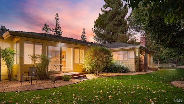 back house at dusk with a yard