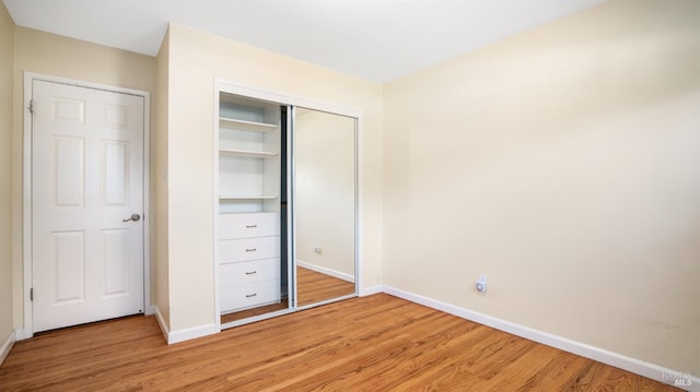 unfurnished bedroom with light hardwood / wood-style flooring and a closet