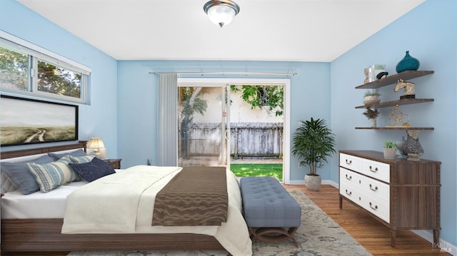 bedroom featuring multiple windows, access to outside, and dark hardwood / wood-style floors