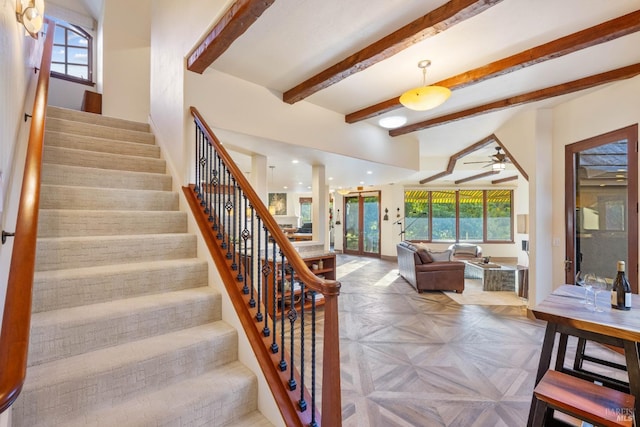 staircase featuring beamed ceiling, parquet floors, and ceiling fan