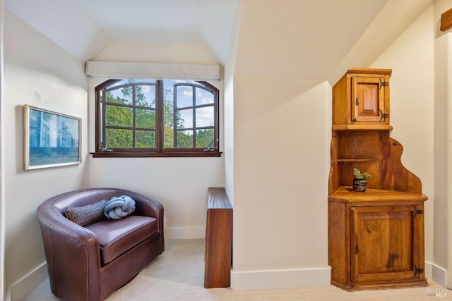 living area featuring light carpet and lofted ceiling