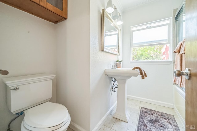 bathroom featuring toilet, baseboards, ornamental molding, and tile patterned flooring