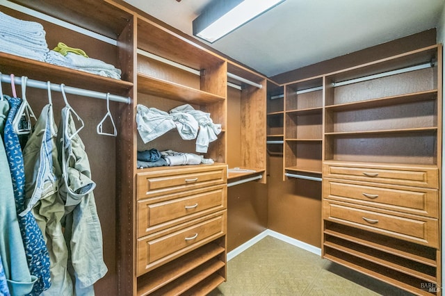 spacious closet with built in desk and tile patterned floors