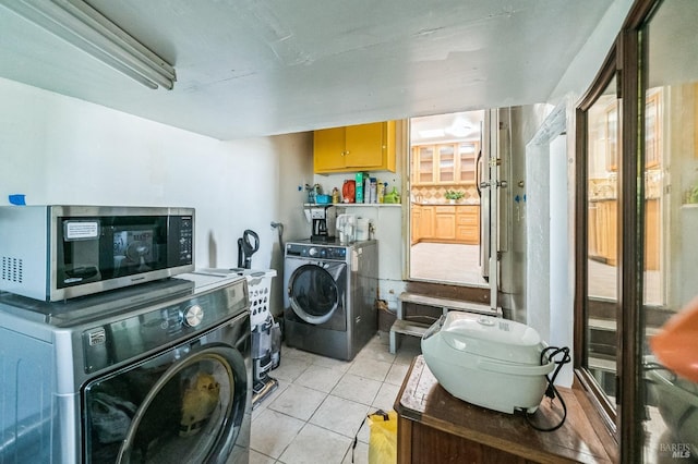 washroom with light tile patterned floors, laundry area, and washer and clothes dryer