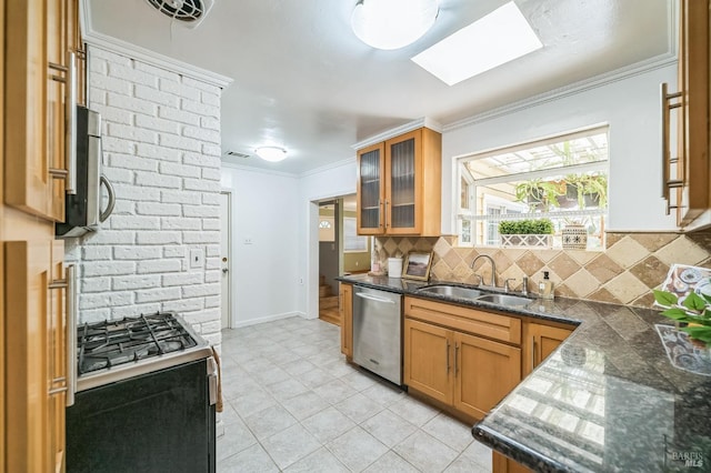 kitchen featuring a skylight, crown molding, sink, and stainless steel appliances