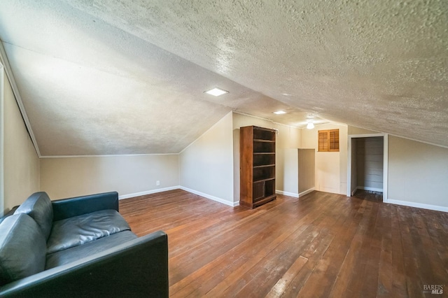 bonus room featuring baseboards, vaulted ceiling, a textured ceiling, and hardwood / wood-style floors