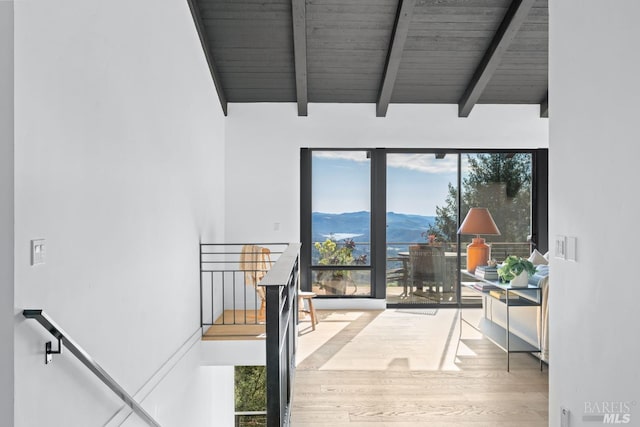 doorway featuring vaulted ceiling with beams, hardwood / wood-style floors, a mountain view, and wooden ceiling