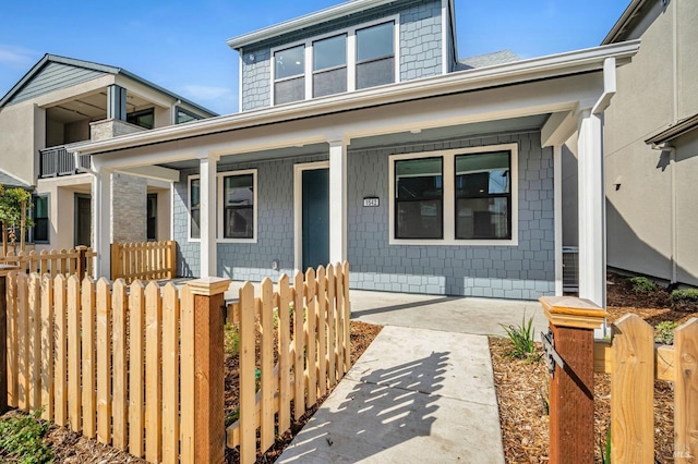 view of front of property with a fenced front yard and a porch