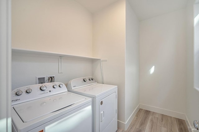 laundry room featuring laundry area, light wood-style floors, independent washer and dryer, and baseboards