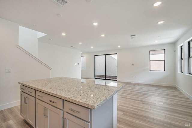 kitchen featuring visible vents, recessed lighting, a kitchen island, and light wood-style floors