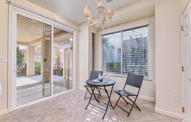 interior space with light tile patterned flooring, a notable chandelier, and a healthy amount of sunlight