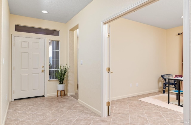 tiled entryway featuring a textured ceiling