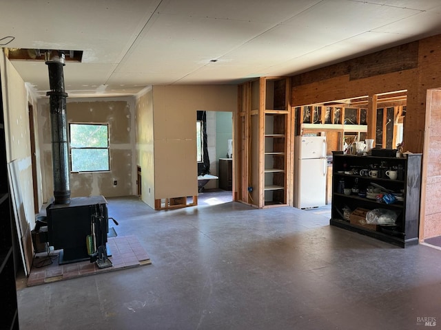 interior space with a wood stove and concrete flooring