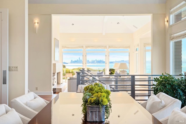 interior space with beamed ceiling, a water view, and hardwood / wood-style flooring