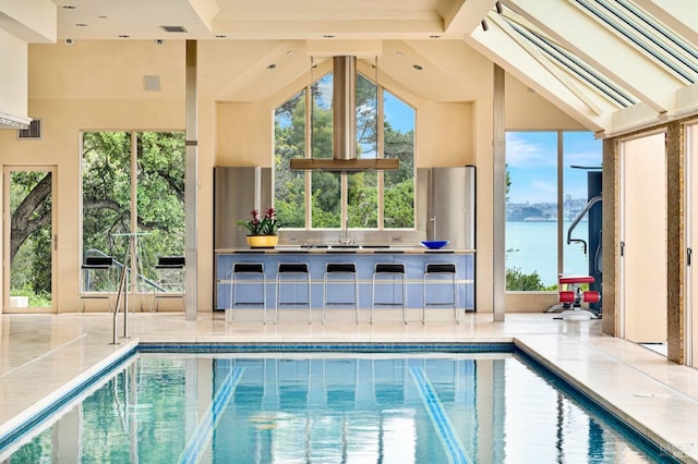 view of swimming pool featuring a water view and a skylight