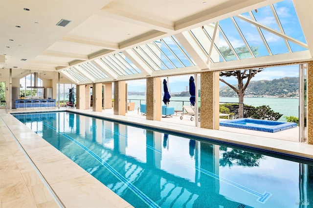 view of pool with a patio area, an in ground hot tub, and a water view