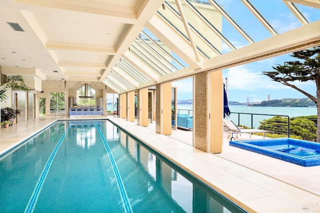 view of swimming pool with a water view, an in ground hot tub, and a patio