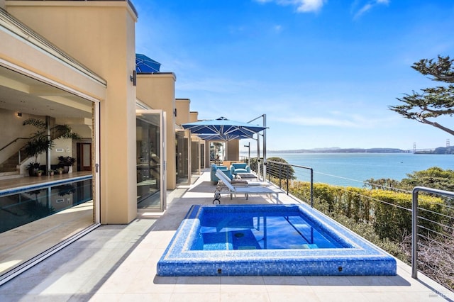 view of swimming pool featuring a patio area, an in ground hot tub, and a water view