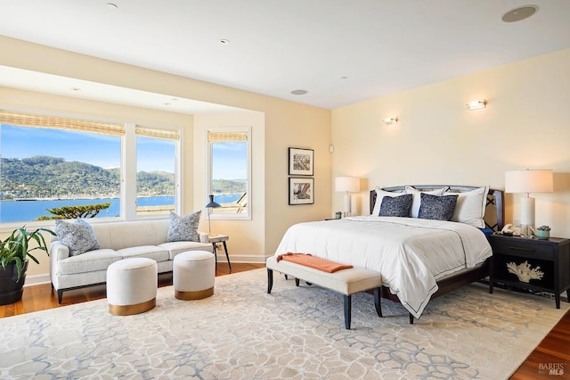 bedroom featuring a water view and wood-type flooring