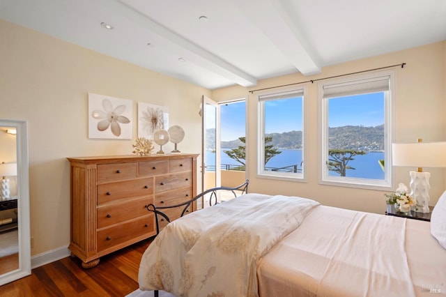 bedroom with beamed ceiling, dark wood-type flooring, and a water view