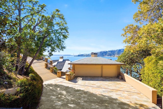 view of front of house featuring a garage and a water view