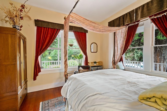 bedroom with dark wood-style floors and baseboards