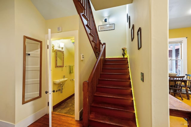 stairway with baseboards and wood finished floors