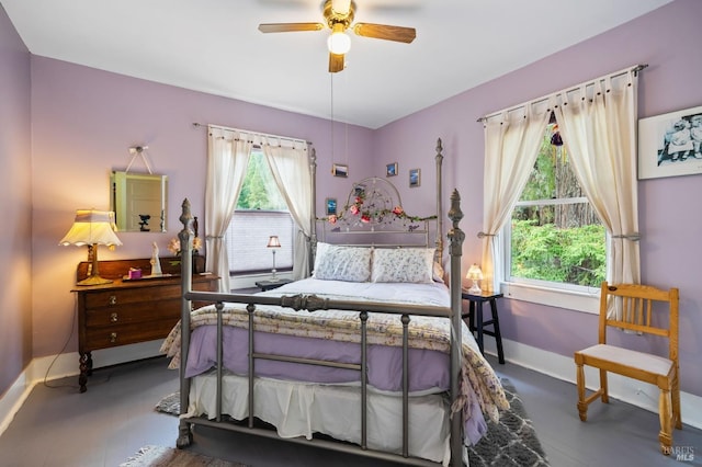 bedroom featuring ceiling fan, multiple windows, and baseboards