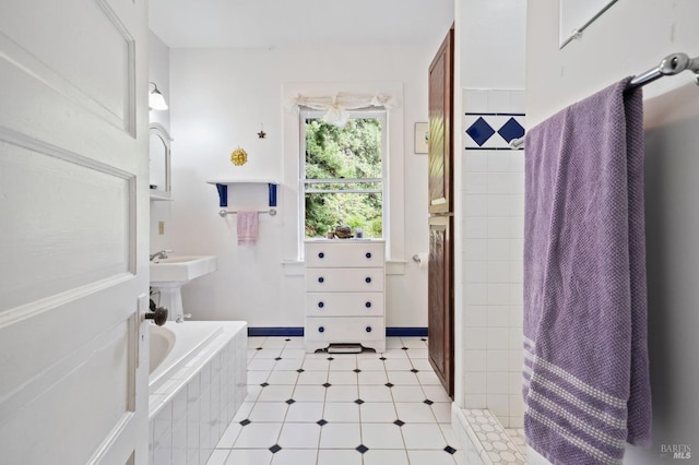 full bath with a relaxing tiled tub and baseboards