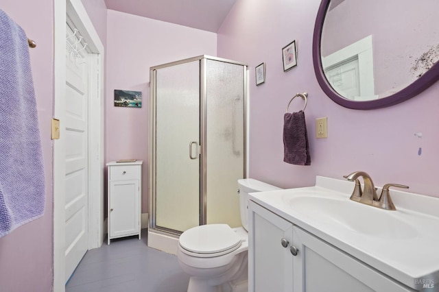 full bathroom featuring toilet, a stall shower, and vanity