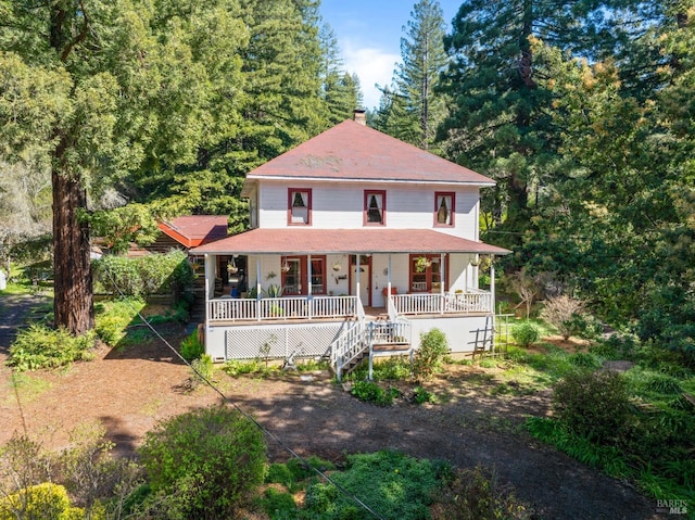 view of front of house featuring covered porch, stairway, and a chimney