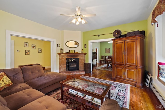 living room featuring a baseboard heating unit, dark wood-type flooring, and ceiling fan