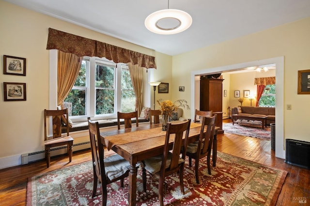 dining area with baseboards, a baseboard radiator, a chandelier, and dark wood-style flooring