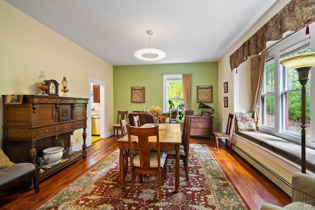 dining room with baseboard heating, wood finished floors, and a wealth of natural light